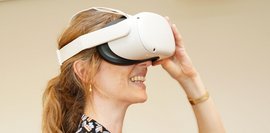 Eine Frau, die eine Virtual-Reality Brille trägt und lacht